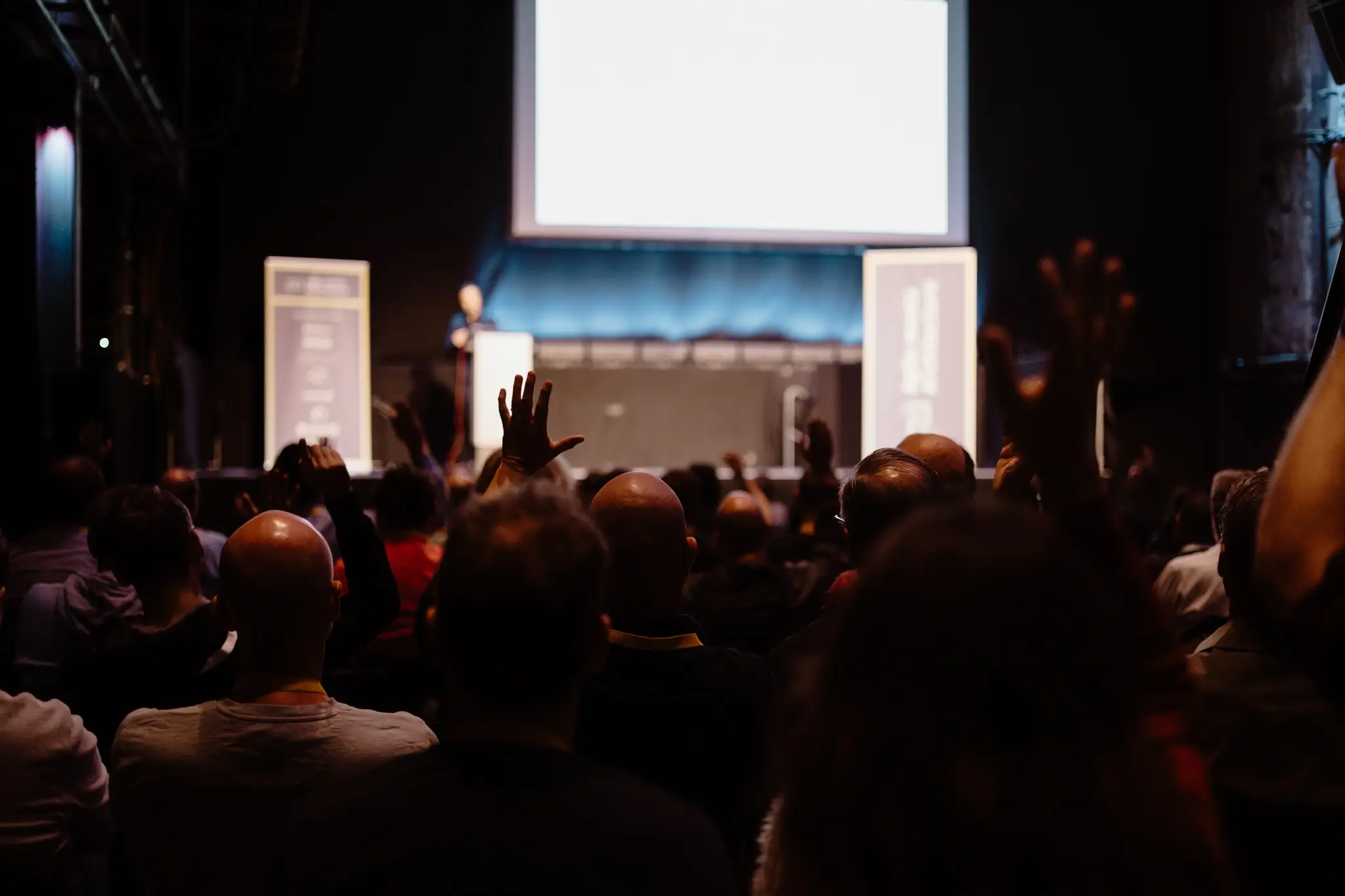 Audience raising hands in front of the stage