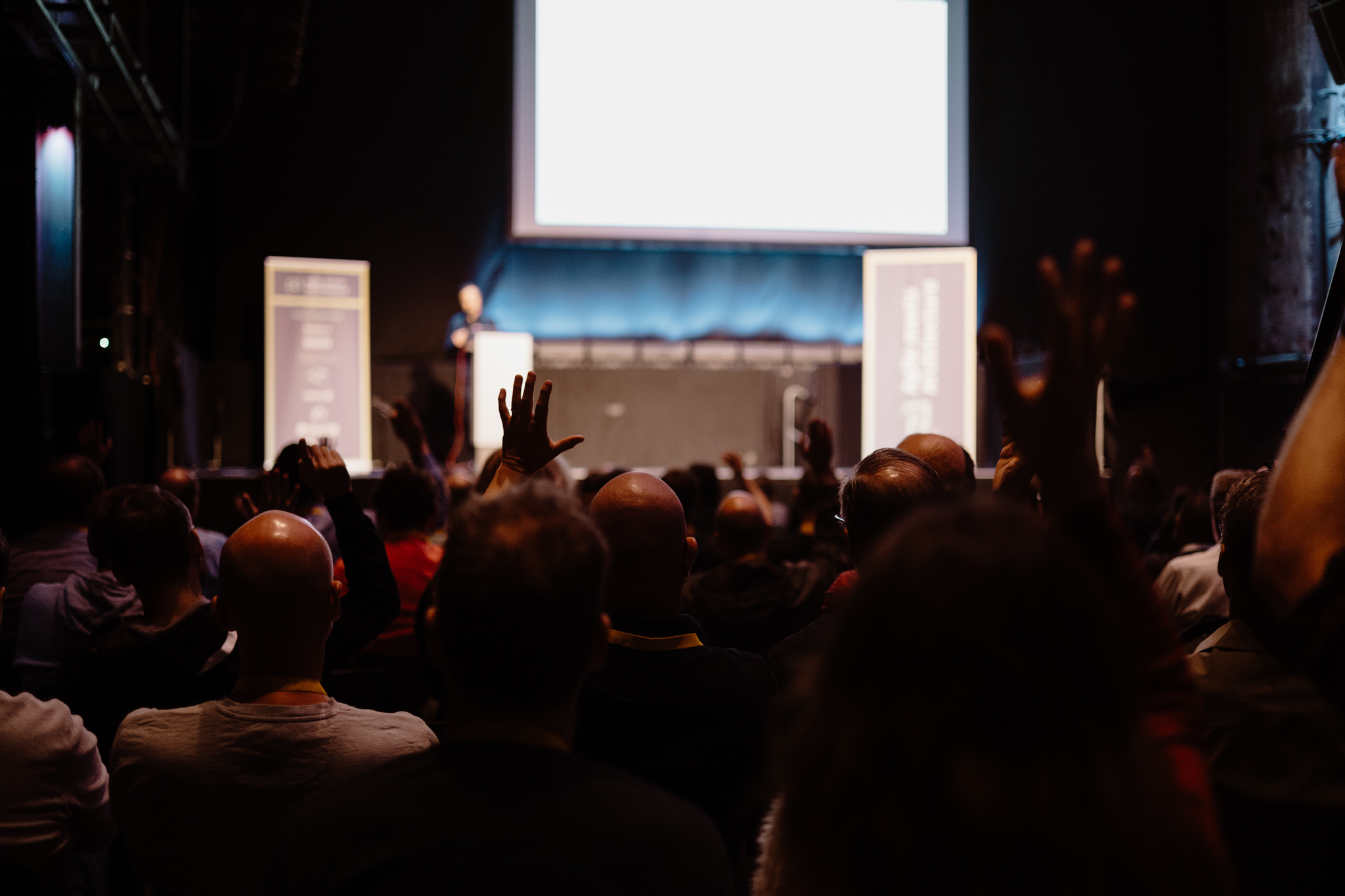 Audience raising hands in front of the stage