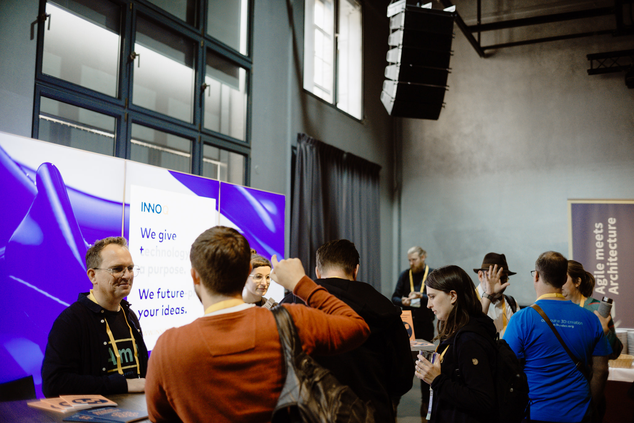 Attendees talking at a sponsor booth between sessions