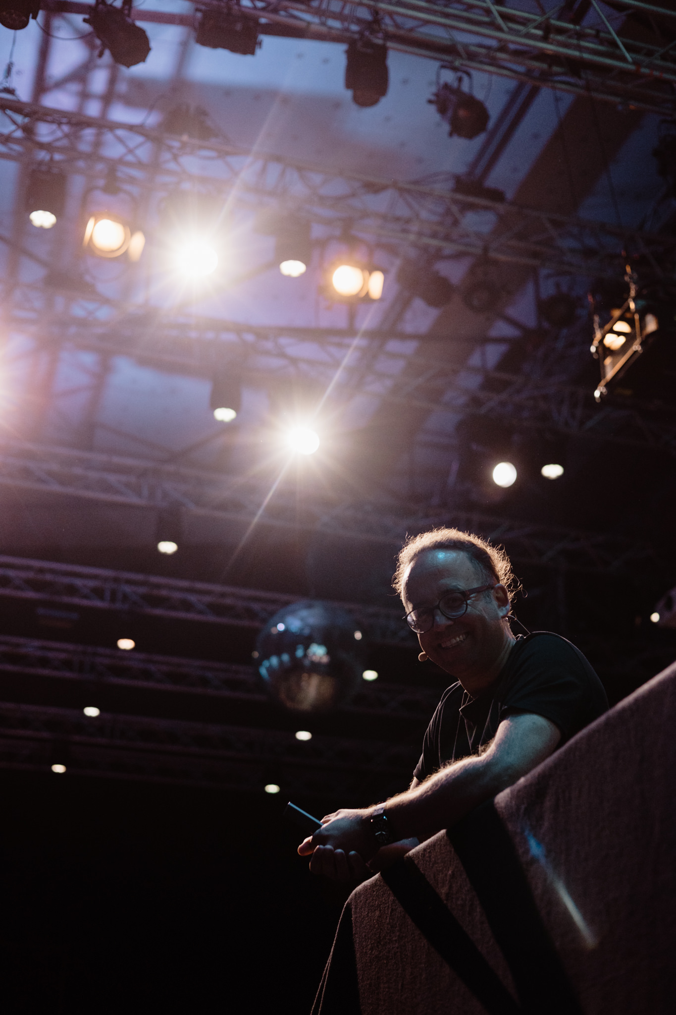 Attendee at the balcony rail under the light rig