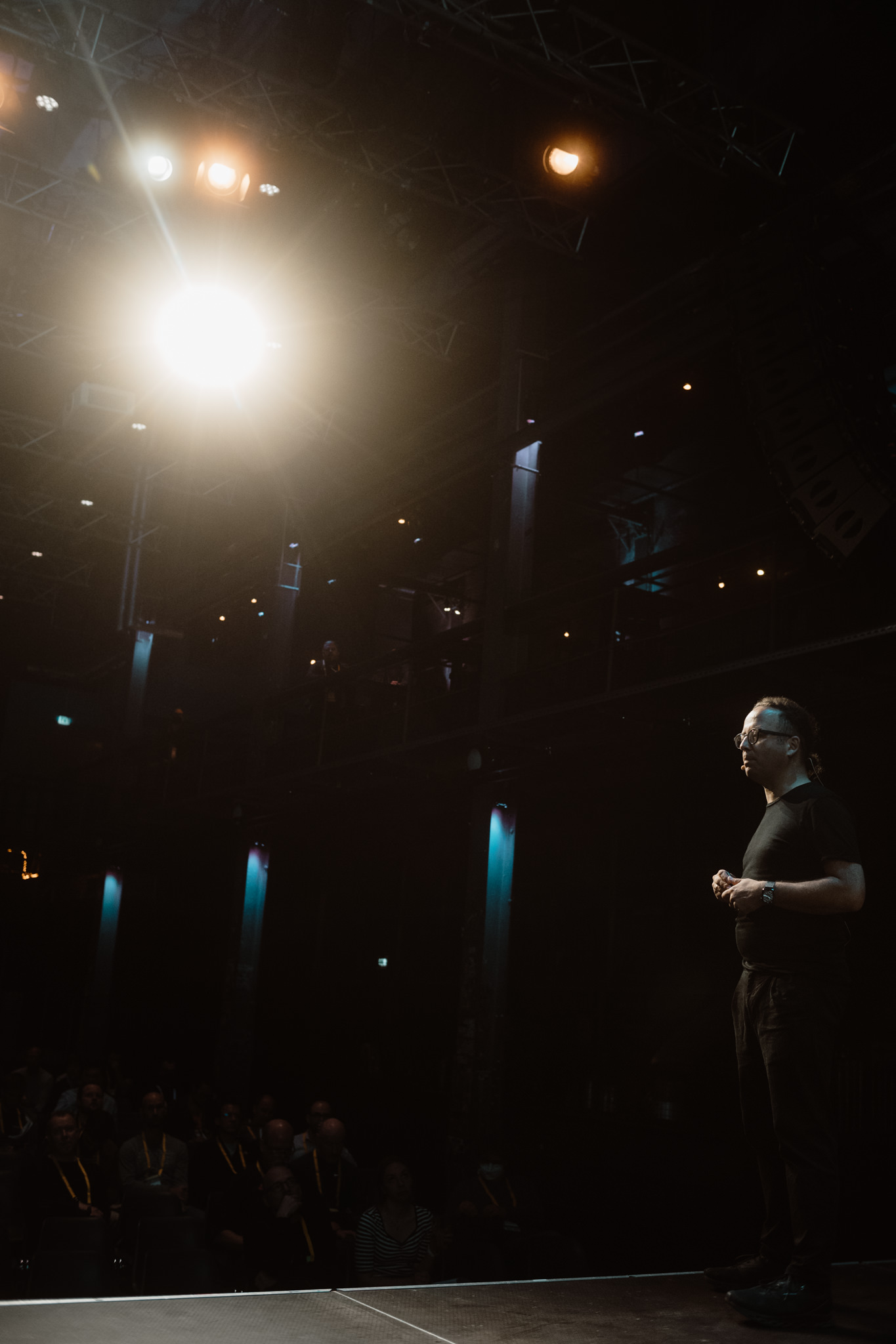 Speaker on stage against a bright spotlight