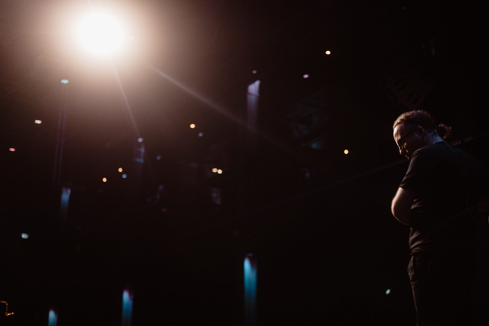 Speaker on stage under a single warm spotlight